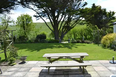 a picnic table in the middle of a garden at Nanis in Crantock