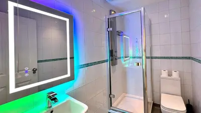 a bathroom with a shower and a sink and a toilet at Reef Lodge in Newquay