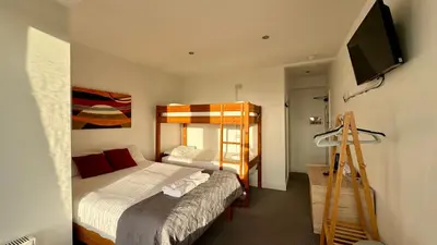 a bedroom with a bed and a bunk bed at Reef Lodge in Newquay
