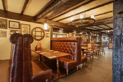 a dining room with a table and leather booths at The Jamaica Inn, Bodmin, Cornwall - The Coaching Inn Group in Bolventor