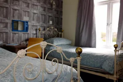 a bedroom with two beds and a window at Bedlam House in Newquay