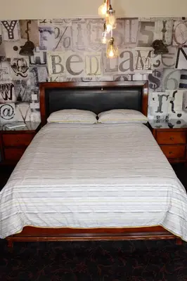 a bedroom with a large bed with a wooden headboard at Bedlam House in Newquay