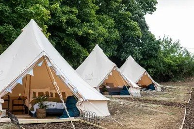 a row of white tents in a field at Three Tuns in Helston