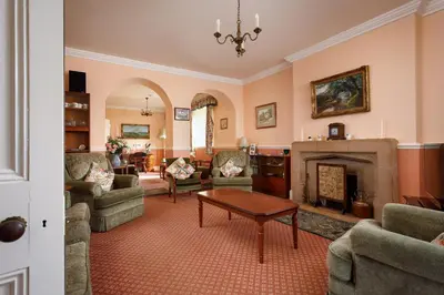 a living room filled with furniture and a fireplace at Bucklawren Farm in Looe