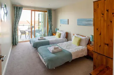 two beds in a room with a balcony at 2-bedroom Apartment - Fistral Beach in Newquay