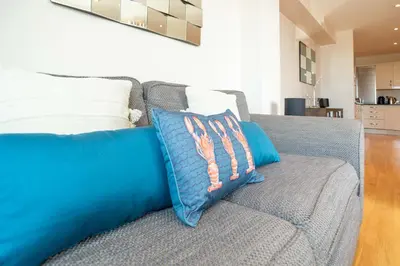 a couch with two pillows on it in a living room at 2-bedroom Apartment - Fistral Beach in Newquay