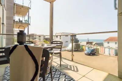 a balcony with a table and a view of the ocean at 2-bedroom Apartment - Fistral Beach in Newquay