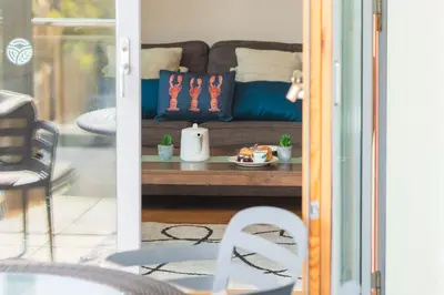 a living room with a couch and a table at 2-bedroom Apartment - Fistral Beach in Newquay