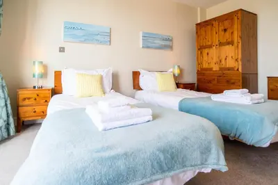 a bedroom with two beds with towels on them at 2-bedroom Apartment - Fistral Beach in Newquay