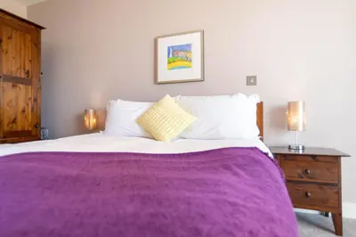 a bedroom with a large bed with a purple blanket at 2-bedroom Apartment - Fistral Beach in Newquay