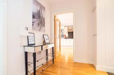 a white room with a desk and a hallway at 2-bedroom Apartment - Fistral Beach in Newquay
