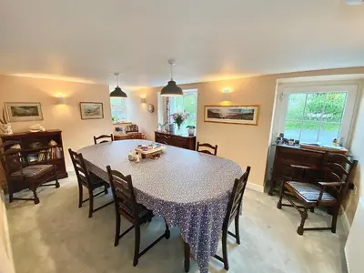 a dining room with a table and chairs at Lynwood House Bed and Breakfast in Tregoney