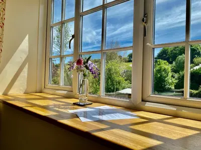 a vase of flowers sitting on a window sill at Lynwood House Bed and Breakfast in Tregoney