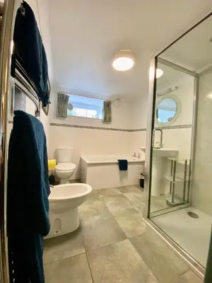a bathroom with a toilet and a glass shower at Lynwood House Bed and Breakfast in Tregoney