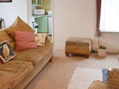 a living room with a couch and a stool at Little Whiteleigh in Week Saint Mary