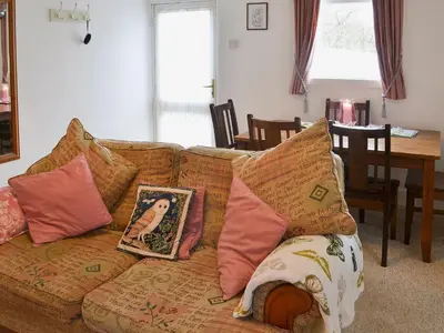 a couch with pillows on it in a living room at Little Whiteleigh in Week Saint Mary