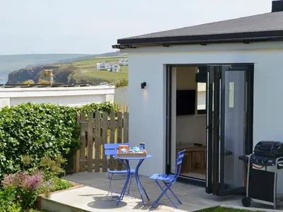 a patio with two chairs and a table in front of a house at Bosun's in Port Isaac