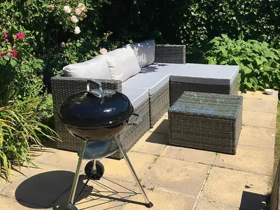 a grill sitting next to a bench with a sofa at Bosun's in Port Isaac