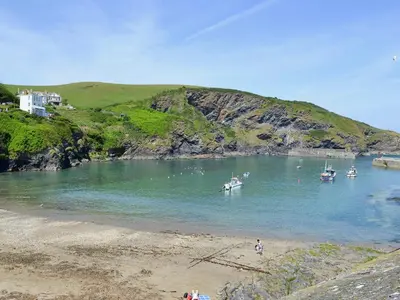 a beach with boats in a body of water at Bosun's in Port Isaac