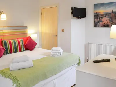 a bedroom with a bed with towels on it at Chapel Barn in Bodmin