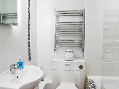 a white bathroom with a toilet and a sink at Chapel Barn in Bodmin
