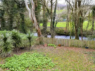 a wooden fence in a garden with plants at Chapel Barn in Bodmin