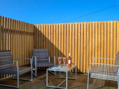 a patio with two chairs and a table with a bottle of wine at Towan View Loft in Newquay