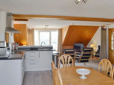 a kitchen and dining room with a table and chairs at Towan View Loft in Newquay