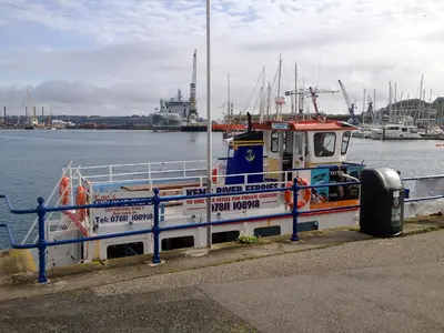 a boat is docked at a dock in the water at Roland Cottage in Falmouth