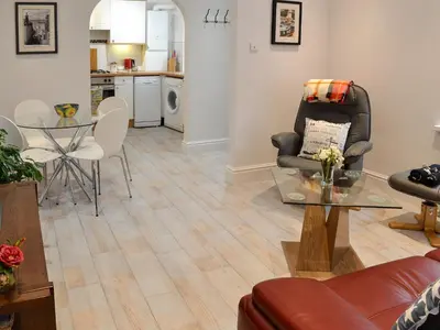 a living room with a chair and a table at Roland Cottage in Falmouth