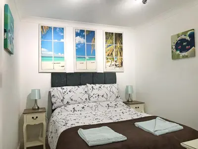 a bedroom with a bed with a view of the beach at Roland Cottage in Falmouth