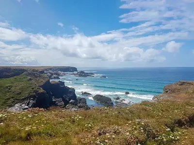 a view of the ocean from a hill with the coastline at Trevone in St Merryn