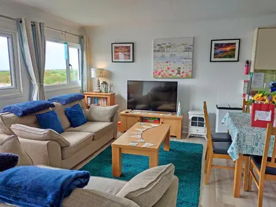 a living room with a couch and a tv at Trevone in St Merryn