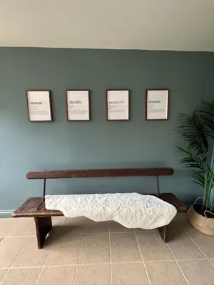 a bench in a room with four pictures on the wall at Bogee Farm in Padstow