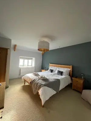 a bedroom with a large bed with a blue wall at Bogee Farm in Padstow