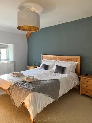 a bedroom with a large bed with a blue wall at Bogee Farm in Padstow