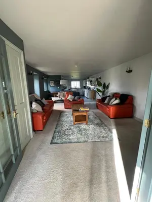a living room with red couches and a table at Bogee Farm in Padstow