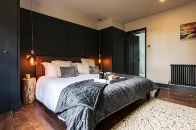 a bedroom with a large bed with a black headboard at Bogee Farm in Padstow