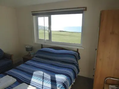 a small bedroom with a bed and a window at Longbeach- Adults Only in Newquay