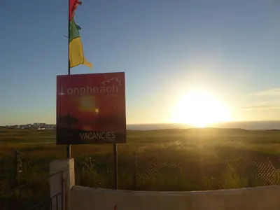 a sign on a fence with the sunset in the background at Longbeach- Adults Only in Newquay