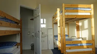 a room with three bunk beds and a bathroom at Longbeach- Adults Only in Newquay