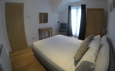 a bedroom with a large white bed with pillows at Rawley point in Newquay