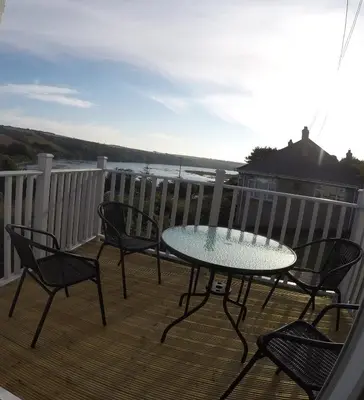 a patio with a table and chairs on a deck at Rawley point in Newquay