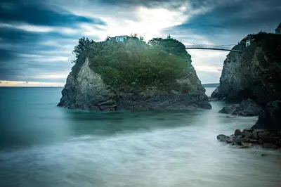 a bridge on top of a cliff over a body of water at Lazy Waves in Newquay