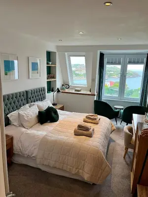 a bedroom with a large bed with two towels on it at Lazy Waves in Newquay