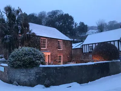 a brick house with snow on top of it at SPRING GARDENS B&B in Wadebridge