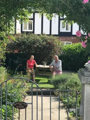 two people sitting at a table in a garden at SPRING GARDENS B&B in Wadebridge