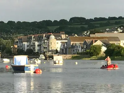a man standing on a boat in a body of water at SPRING GARDENS B&B in Wadebridge