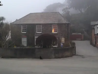 a house with a cat sitting in front of it at SPRING GARDENS B&B in Wadebridge