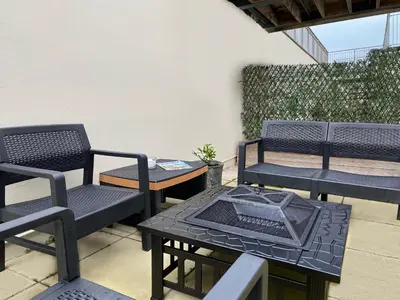 a patio with two chairs and a table with a grill at OHANA HOUSE - Unbeatable Location - UK's Best Beaches in Newquay